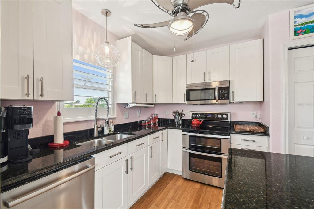 3227 Rose Arbor Drive Hernando Beach, FL 34607 - Photo 12 of 52 a kitchen with stainless steel appliances a sink cabinets and wooden floor
