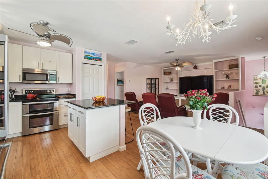 3227 Rose Arbor Drive Hernando Beach, FL 34607 - Photo 13 of 52 a living room with kitchen island furniture and a flat screen tv