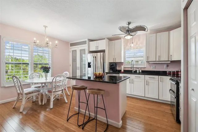 a kitchen with stainless steel appliances granite countertop white cabinets and wooden floor