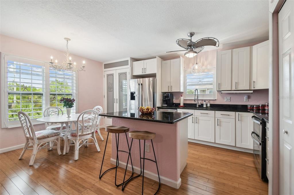 3227 Rose Arbor Drive Hernando Beach, FL 34607 - Photo 14 of 52 a kitchen with stainless steel appliances granite countertop white cabinets and wooden floor