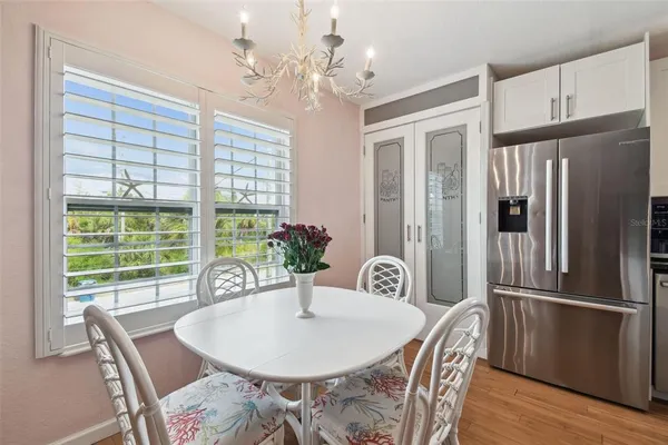 a dining room with furniture a chandelier and wooden floor