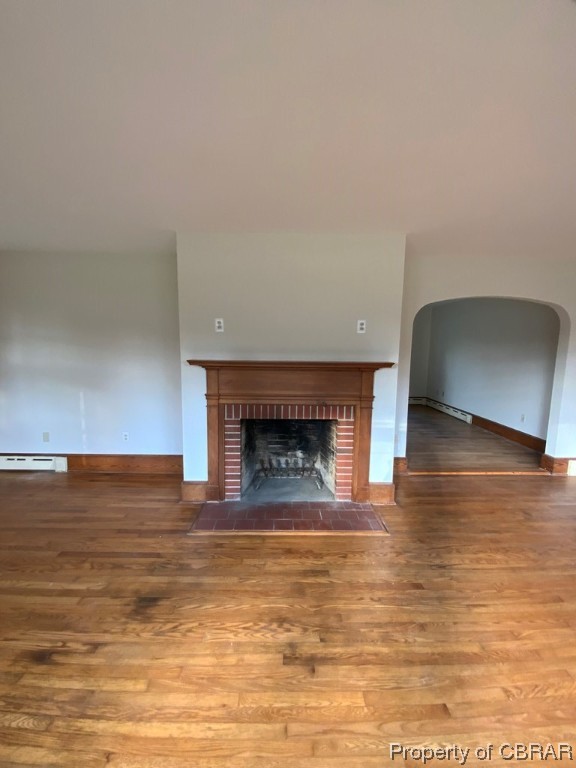 14 Light Street Heathsville, VA 22473 - Photo 6 of 18 Unfurnished living room featuring dark hardwood / wood-style floors, a brick fireplace, and a baseboard radiator