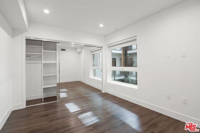 an empty room with wooden floor and closet