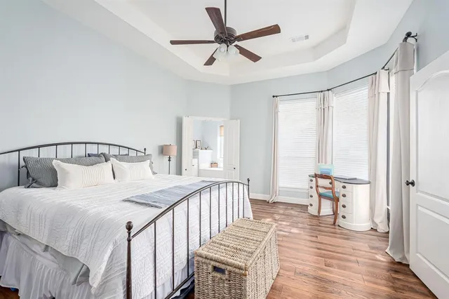 a bedroom with a bed and a flat tv screen on the dresser