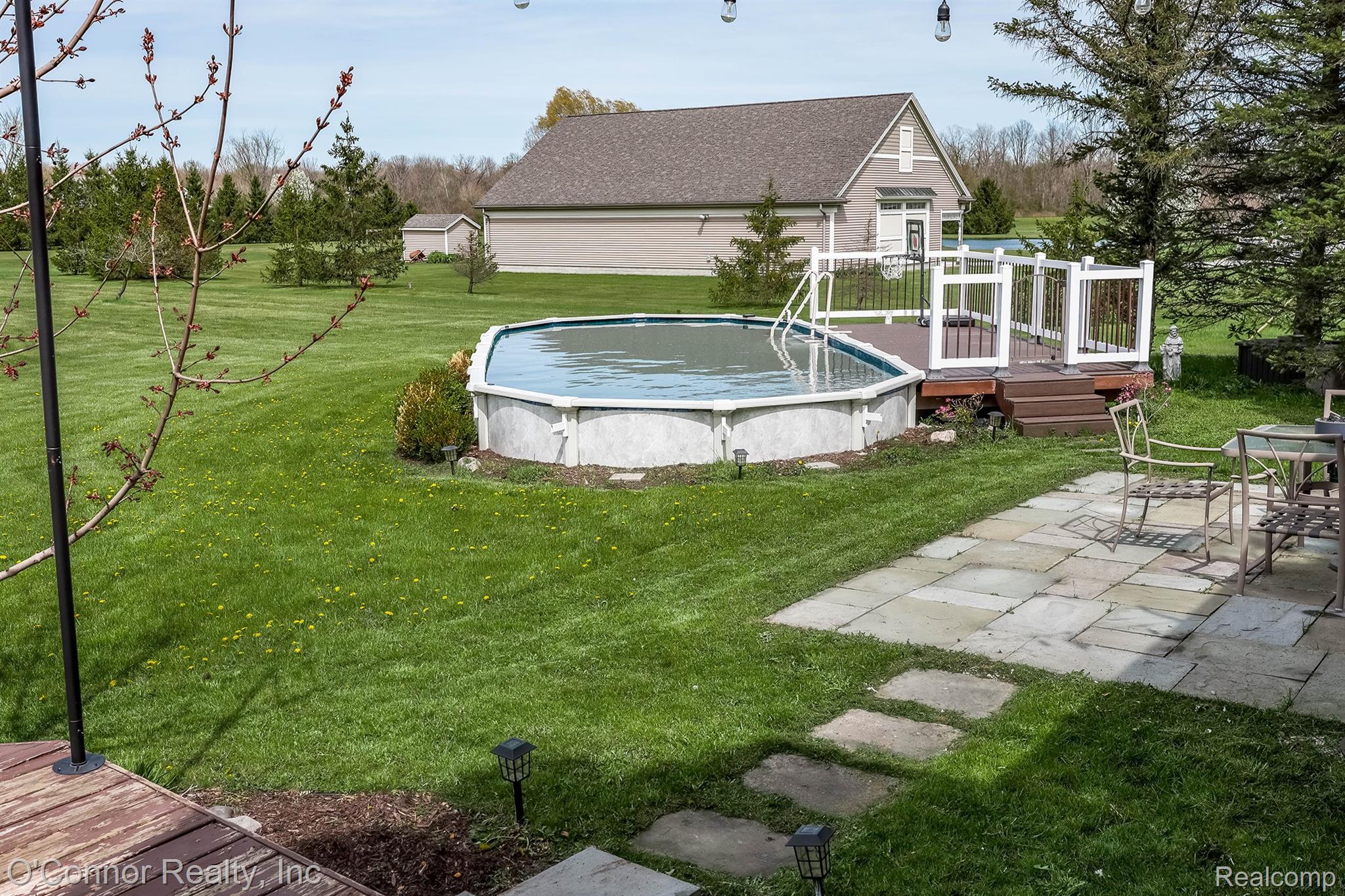 7978 Frith Road Columbus, MI 48063 - Photo 36 of 56 View of grassy yard featuring a deck and an outdoor pool