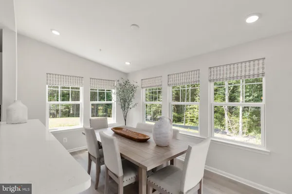 a view of a dining room with furniture large windows and wooden floor