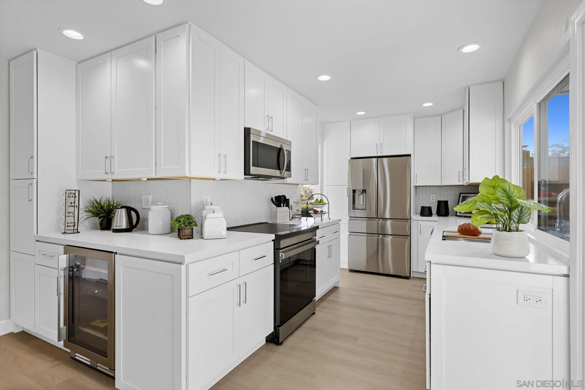 3252 Eichenlaub Street San Diego, CA 92117 - Photo 8 of 36 a kitchen with a sink stainless steel appliances and white cabinets