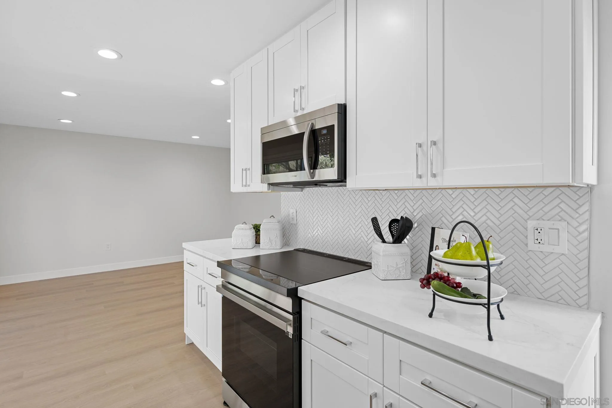 3252 Eichenlaub Street San Diego, CA 92117 - Photo 9 of 36 a kitchen with stainless steel appliances granite countertop a sink a stove and cabinets