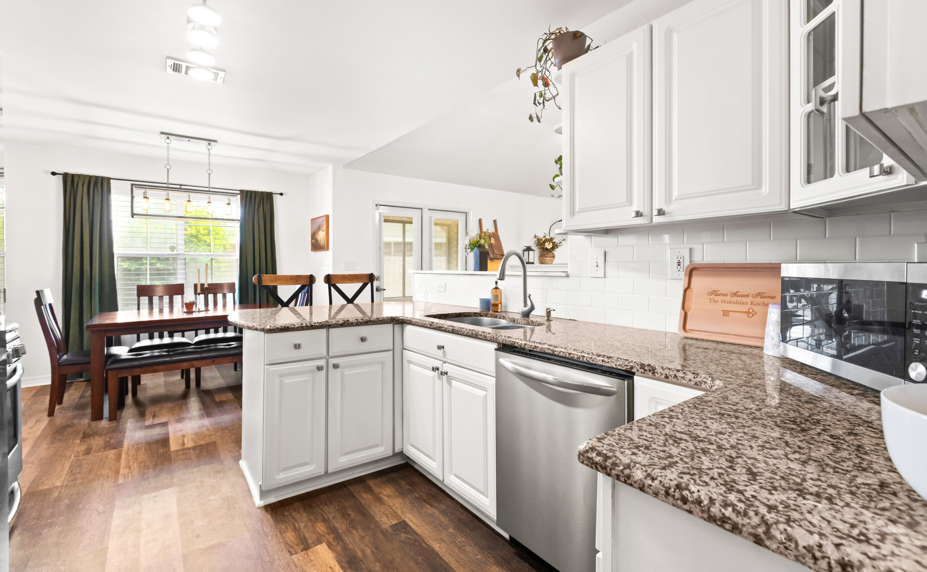 380 Sonora Road Destin, FL 32541 - Photo 25 of 62 a kitchen with stainless steel appliances granite countertop a stove a sink and white cabinets with wooden floor