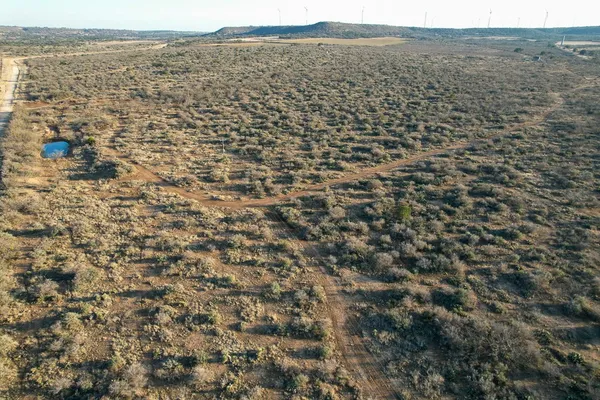 an aerial view of house with yard and mountain in middle