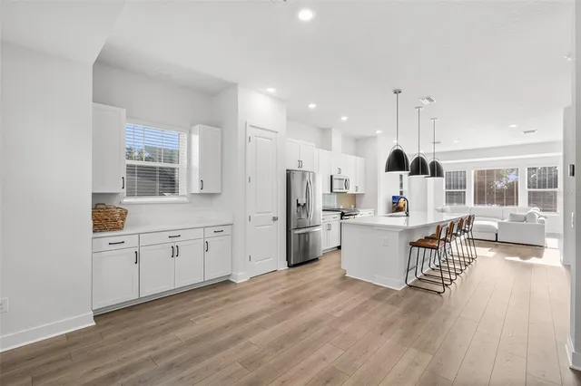 a kitchen with stainless steel appliances a refrigerator a stove a sink dishwasher and a fireplace with wooden floor