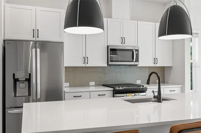 a kitchen with a stove a sink a dining table and chairs