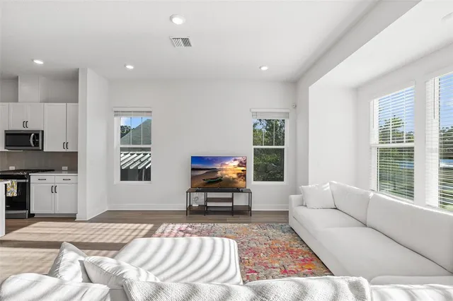 a living room with furniture and a wooden floor