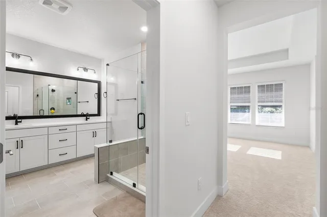 a bathroom with a shower sink and mirror