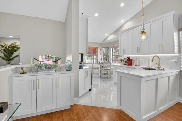 a kitchen with white cabinets and sink