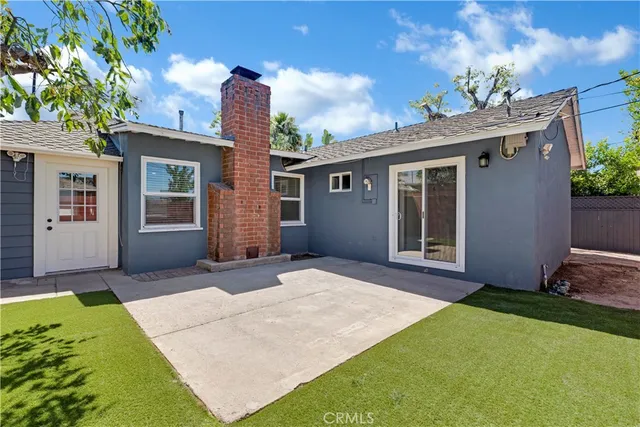 a view of a house with a yard and potted plants