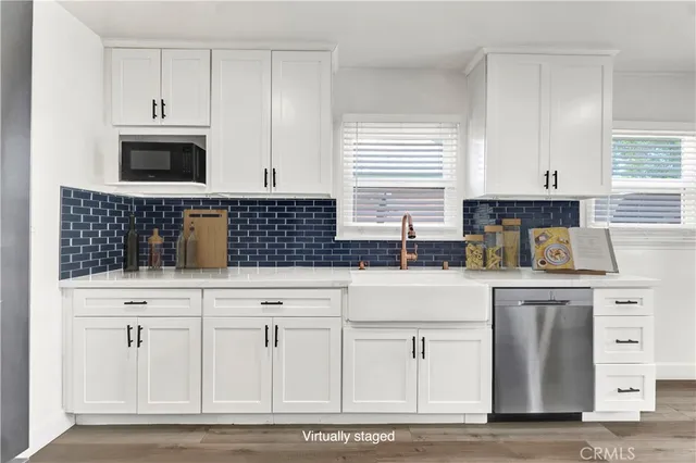 a kitchen with white cabinets and appliances