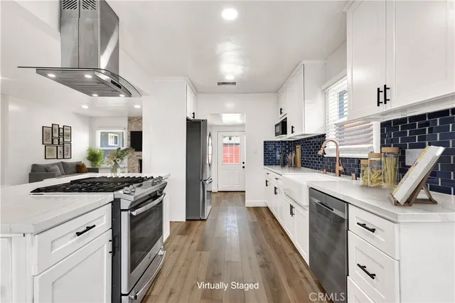 a kitchen with stainless steel appliances granite countertop a sink a stove and cabinets