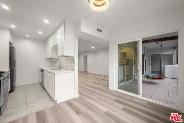 a kitchen with a sink cabinets and wooden floor