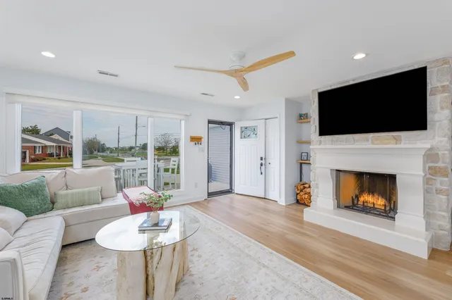 a living room with furniture a flat screen tv and a fireplace