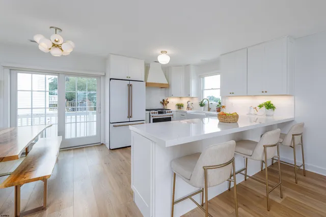 a kitchen with stainless steel appliances a dining table chairs and chandelier