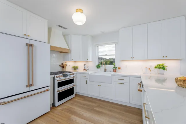 a kitchen with white cabinets and white appliances