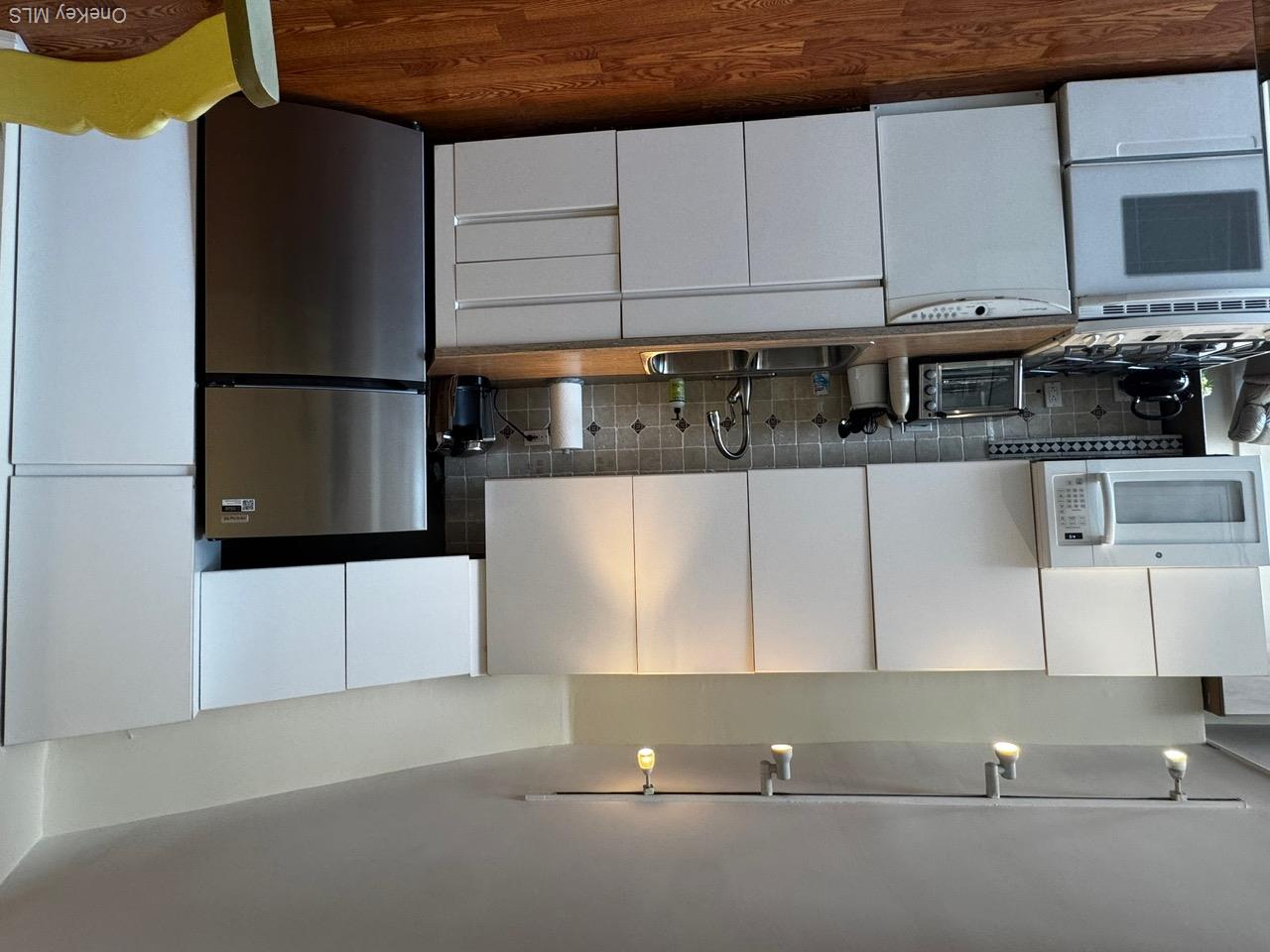 830 Shore Road, Unit 4M Long Beach, NY 11561 - Photo 4 of 20 Kitchen with fridge, decorative backsplash, stove, dark wood-style floors, and dishwashing machine