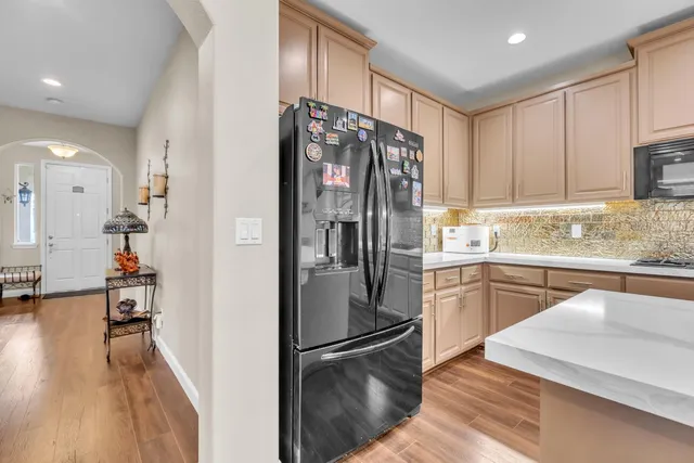 a kitchen with stainless steel appliances granite countertop a refrigerator and a sink