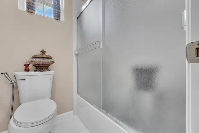 a white toilet sitting next to a bath tub