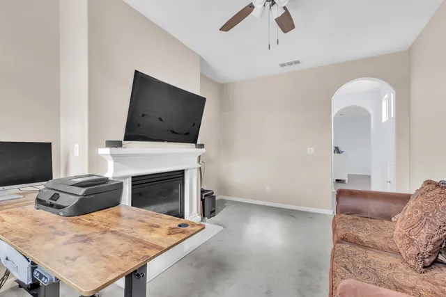 a living room with furniture a flat screen tv and a fireplace