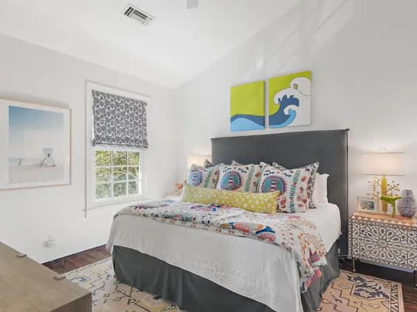 a bedroom with a bed and painting on the wall