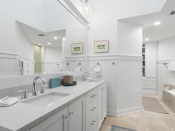 a bathroom with double vanity and a mirror