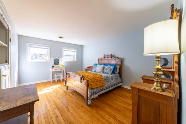 a spacious bedroom with a bed and a dresser with closet