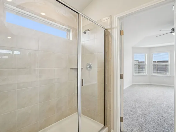 a bathroom with a shower and a glass door