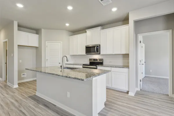 a kitchen with stainless steel appliances granite countertop a stove a sink and a refrigerator
