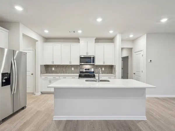 a large kitchen with stainless steel appliances granite countertop a stove a refrigerator a sink and a granite counter tops
