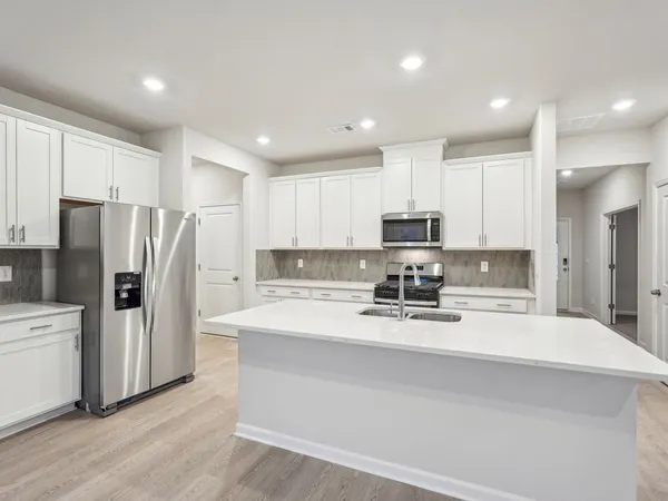 a kitchen with stainless steel appliances a refrigerator sink and microwave