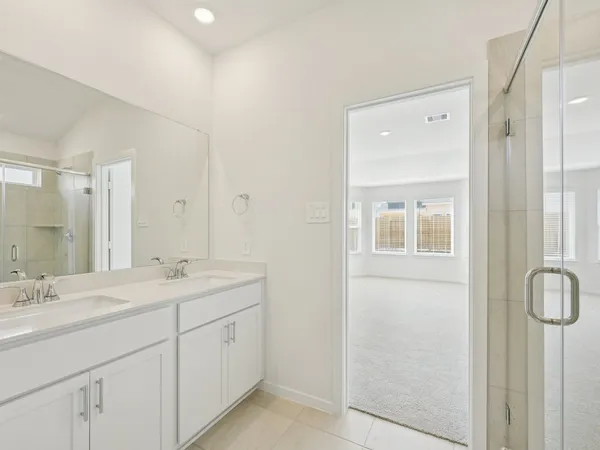 a spacious bathroom with a double vanity sink a mirror and a shower