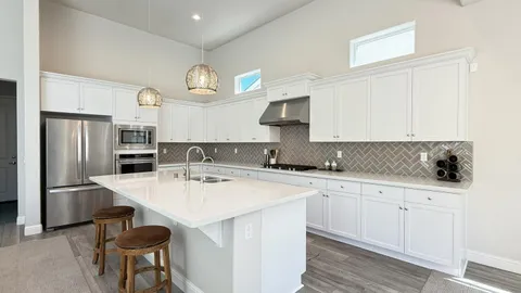 a kitchen with stainless steel appliances a sink a stove a refrigerator and cabinets
