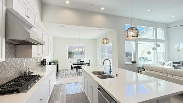 a large white kitchen with a large window and stainless steel appliances
