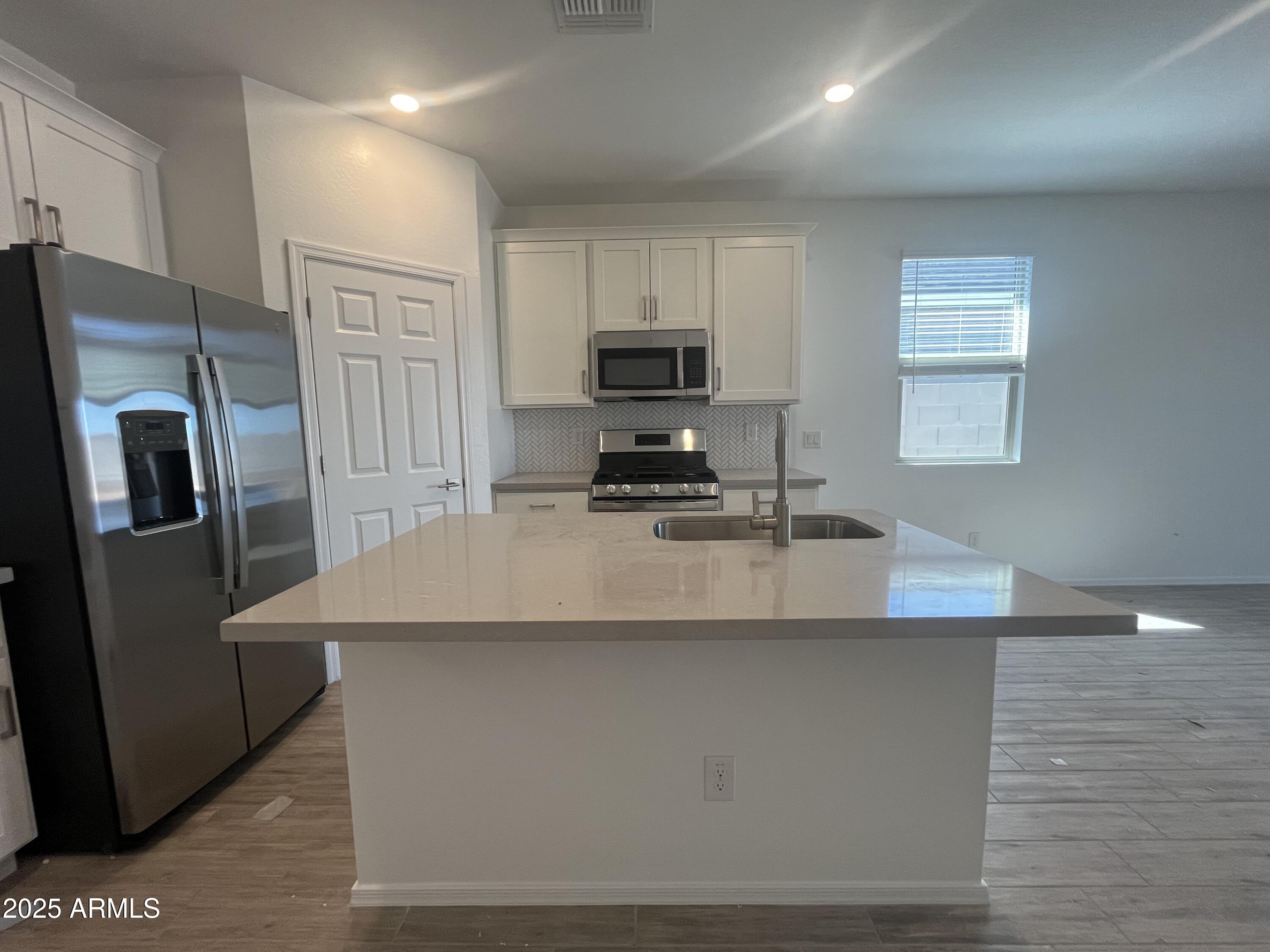 47692 West Moeller Road Maricopa, AZ 85139 - Photo 7 of 31 a kitchen with stainless steel appliances a refrigerator sink and microwave
