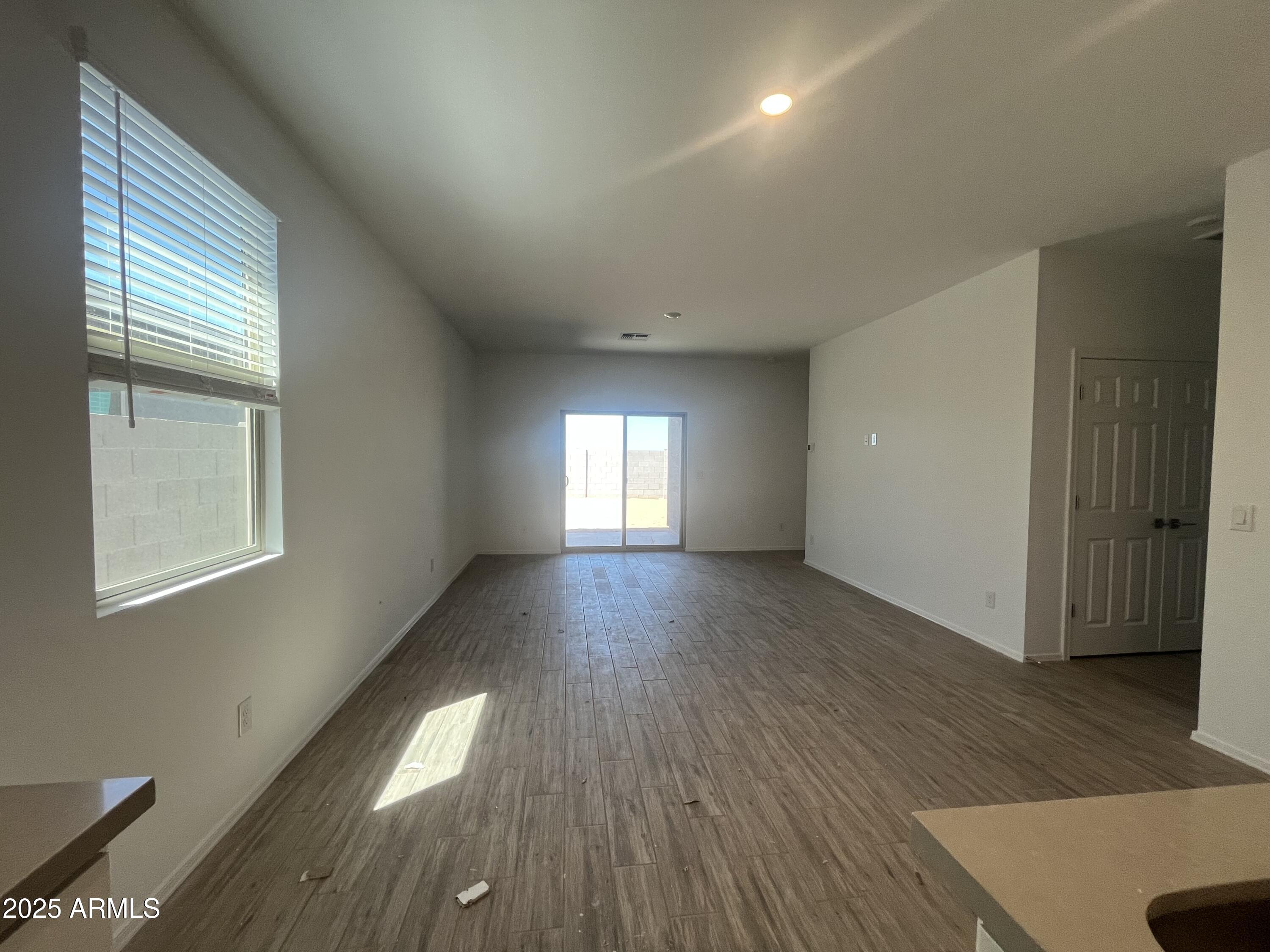 47692 West Moeller Road Maricopa, AZ 85139 - Photo 9 of 31 an empty room with wooden floor and windows