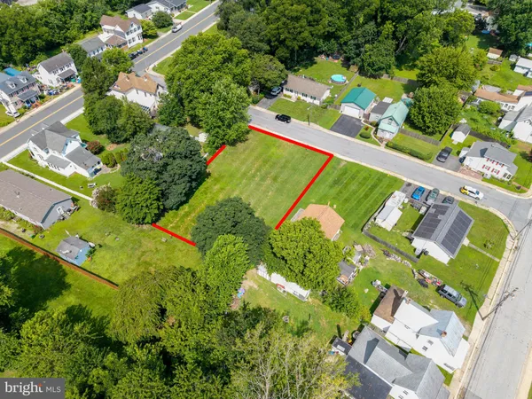 an aerial view of a residential houses with yard