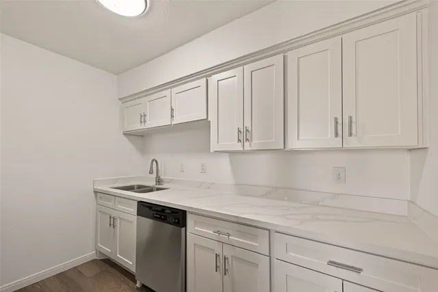 a kitchen with white cabinets and sink