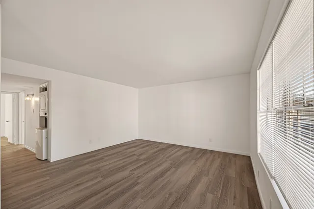 a view of a room with wooden floor and a window