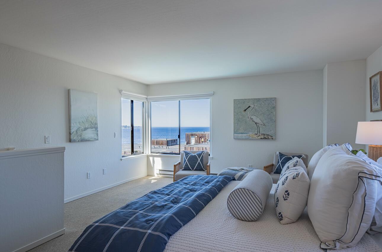 125 Surf Way, Unit 438 Monterey, CA 93940 - Photo 22 of 45 a bedroom with a bed and wooden floor