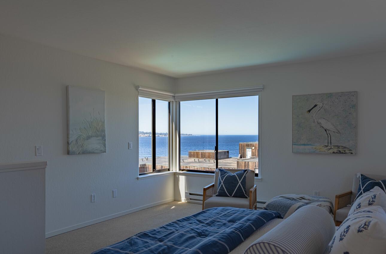 125 Surf Way, Unit 438 Monterey, CA 93940 - Photo 23 of 45 a bedroom with furniture and a window