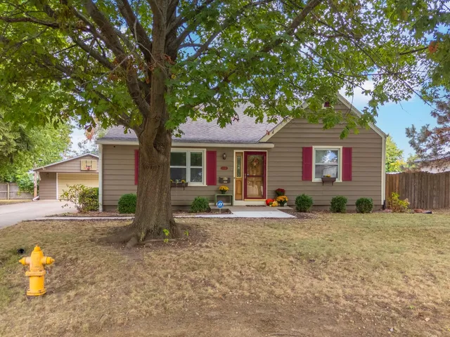 a view of a house with a yard and potted plants
