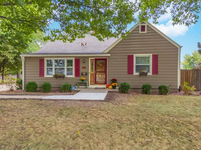 a front view of a house with yard and tree s
