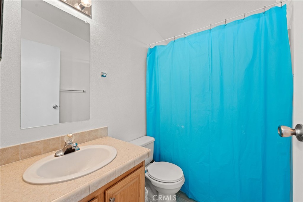 52076 Maxine Avenue Cabazon, CA 92230 - Photo 14 of 35 a bathroom with a sink a toilet and mirror